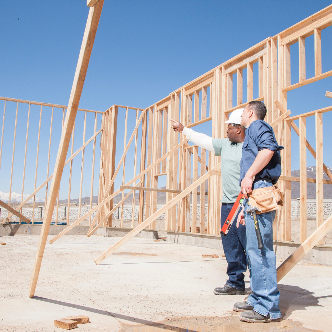 Construction workers building modern affordable housing with community members watching