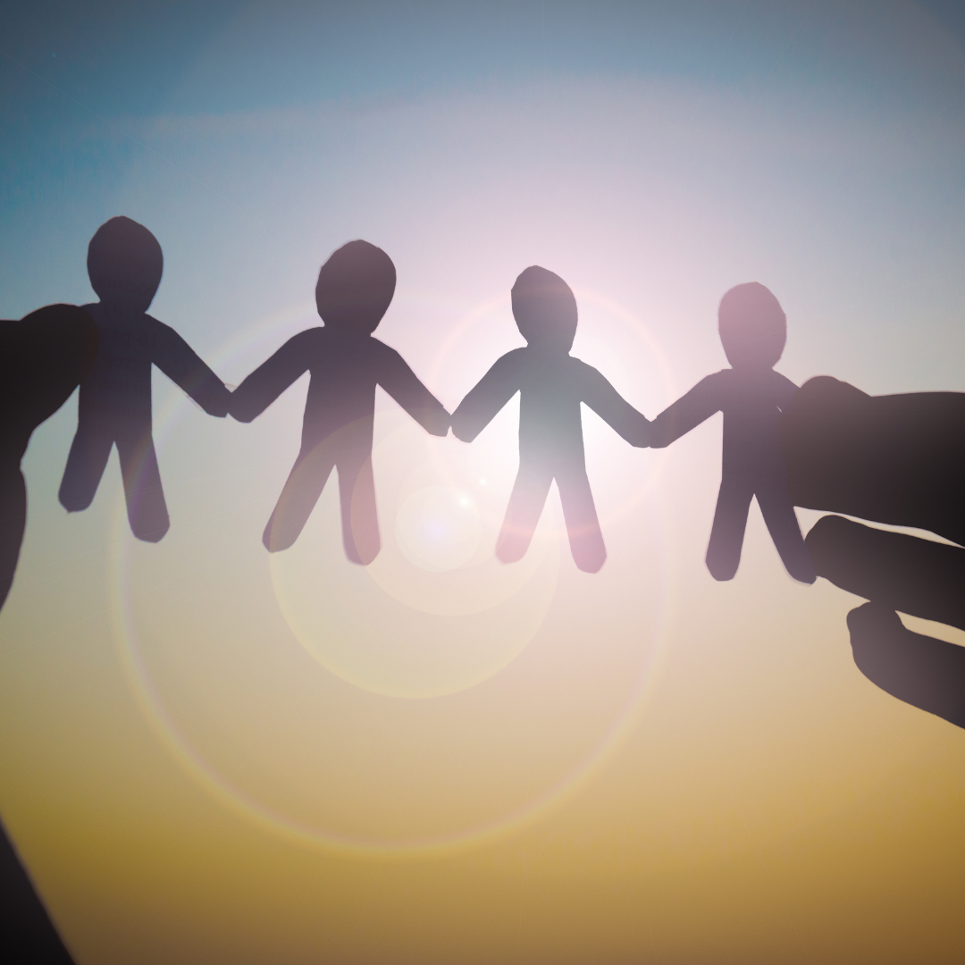 Paper cutout figures holding hands in unity, symbolizing community building and connection